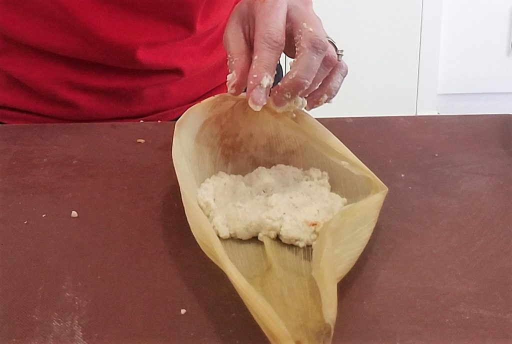 Corn husk with masa pressed for tamale making