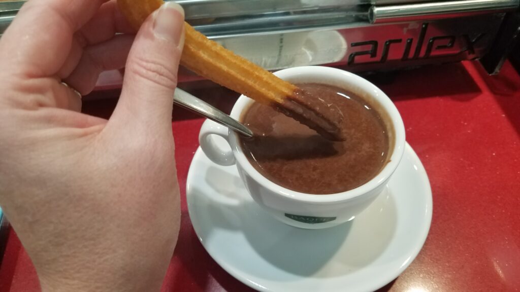 DIpping a churro in hot chocolate, Avila, Spain
